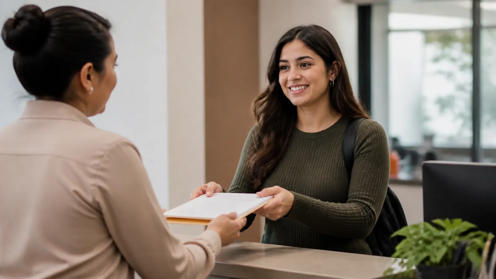 Estudiante entregando su solicitud de beca en la ventanilla del campus